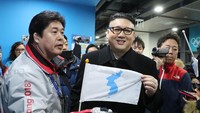 Kim Jong Un KW tampak membawa bendera unifikasi Korea. (Foto: Dok. REUTERS/Lucy Nicholson)