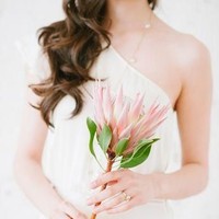 Biasanya pengantin membawa buket bunga ketika berjalan di altar pernikahan. Tapi satu bunga besar yang minimalis namun unik seperti ini menjadi salah satu tren pernikahan 2018. Foto: Pinterest