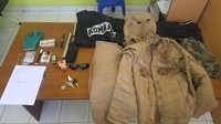 Dari tangan pria tersebut, polisi mengamankan satu double stick bertuliskan Yonif 712 Raider, sebilah pisau dapur, empat butir amunisi, satu sarung tangan, satu baut berukuran 10 cm, uang Rp 10 ribu, sebatang rokok, korek api, jimat, dan rompi hitam bertulisan komando. Selain itu, polisi mengamankan celana training hitam, kacamata hitam, dan penutup kepala mirip tokoh superhero Batman. Baju karung goni itu tampaknya ingin menyerupai seragam personel Brimob. Terdapat jahitan bertulisan Satuan Brimob dan nama Nurul. (Dok. Istimewa)