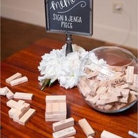 Menulis nama dan tanda tangan di buku undangan sudah tidak zaman lagi? Jika ingin mengikuti tren pernikahan 2018, tulis nama para tamu undangan di kayu Jenga yang nantinya bisa dimainkan berikut. Foto: Pinterest