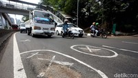 Jalan berlubang tersebut hanya ditandai dengan cat putih.