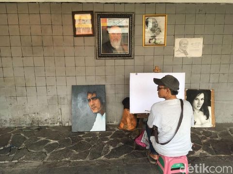 Jaya, pelukis jalanan di trotoar kawasan Kota Tua, Jakarta.