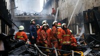 Petugas Damkar menyemprotkan air ke sumber api.