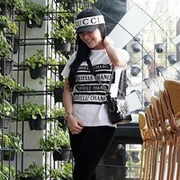 Tampil sangat casual dengan gaya monokrom, Syahrini memadupadankan legging hitam dan kaus Chanel bertuliskan nama pendiri brand tersebut Gabrielle Chanel. Kaus ikonik itu dijual di situs Chanel seharga Rp 12,8 juta. Foto: Instagram