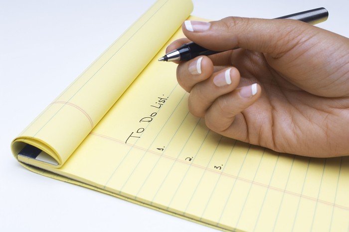 Woman writing list of tasks to do,  close-up of hand