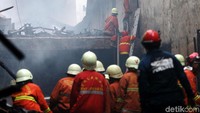 Dengan sigap, petugas Damkar memanjat ke lantai atas menggunakan tangga.