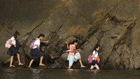 Foto: Pelajar di Desa Kawag, Subic, Provinsi Zambales, di wilayah utara Manila, Filipina, harus melewati tepi pantai berbatu untuk mengikuti kelas (Lorgina Minguito/Reuters)