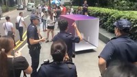Vending machine uang tunai ini sebenarnya merupakan sebuah kotak yang berisi seorang pria di dalamnya. Dari dalam kotak, pria itu menyerahkan uang tunai SGD 50 kepada setiap orang yang memasukkan SGD 3. Foto: Facebook/Channel News Asia