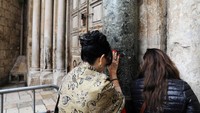 Jemaah berdoa di depan pintu gereja (Foto: Dok. REUTERS/Ammar Awad)