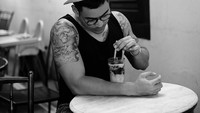 Foto berwarna monokrom ini menunjukkan bahwa Robby Purba doyan kulineran. Di kawasan Glodok, dirinya pun tengah asyik mencicip es cincau jahe. Foto: Instagram @robbypurba