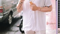 Kalau cuaca sedang terik memang enaknya makan es krim cone. Robby tampak ganteng ya dengan kemeja putih dan topi berwarna krem. Foto: Instagram @robbypurba
