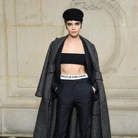 Turut menyempurnakan gaya Cara Delevingne, coat elegan bernuansa monokrom, topi baret yang chic, serta velve ankle boots. (Foto: Getty Images)