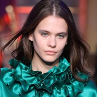 Tak cukup dengan riasan shimmery. Untuk memberikan nuansa yang lebih festive, fashion show Genny menampilkan model dengan riasan mata glitter.  Foto: Getty Images