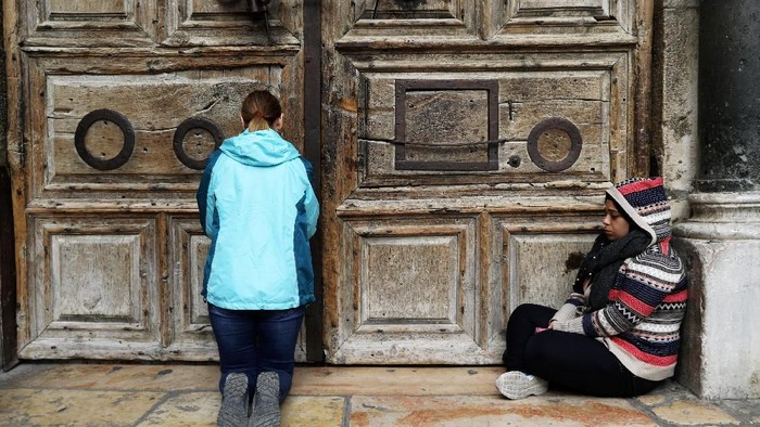 A worshipper stands next to the closed doors of the Church of the Holy Sepulchre in Jerusalems Old City February 27, 2018. REUTERS/Ammar Awad