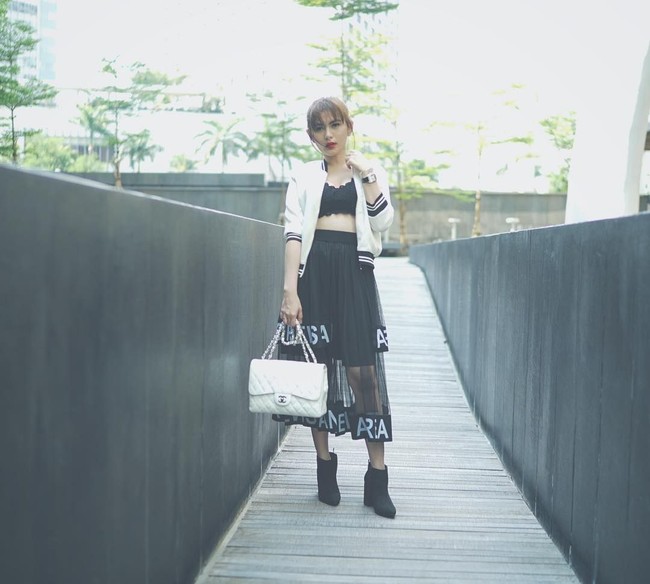 Tampil seksi dengan atasan crop top dan rok transparan, Angela Lee bergaya membawa Chanel Flap Bag Jumbo seharga US$ 5.900. Foto: Instagram