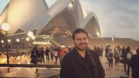 Dengan wajah tampan dan senyum memikat, Sami berfoto dengan Gedung Opera Sydney yang terkenal. (samiyusuf/Instagram)