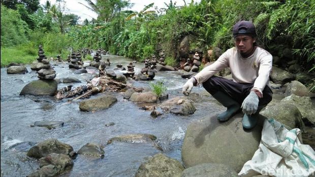 Rahmat Bikin Rock Balancing Disela Memungut Sampah di Sungai