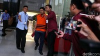 Adriatma tampak mengenakan kaos berkerah abu-abu. Dia juga terlihat menggenggam map warna merah di tangan kanannya.