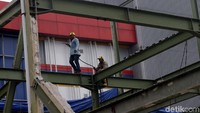 Pekerja mencopot batang-batang besi rangka bangunan tersebut.