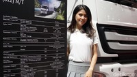 Seorang sales promotion girls (SPG) berpose di samping truk yang dipamerkan dalam ajang pameran bus dan truk tersebut.