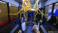 SPG mobil karya anak bangsa menjajal duduk di kursi penumpang.