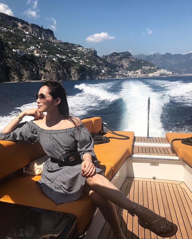 Arissa Cheo menikmati liburan mewahnya naik yacht di Italia dengan mengenakan busana off shoulder dan belt bag atau tas pinggang dari brand Gucci. Foto: Instagram@xarissaxcheox