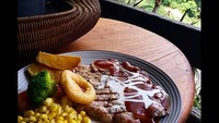 Menu makanannya nggak kalah menggoda. Ini adalah sepiring steak tender T-bone yang disajikan bersama kentang, jagung dan sayuran. Foto: instagram @congogallery