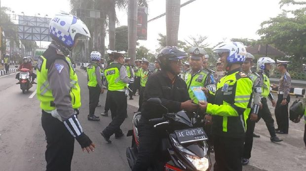 Memberikan selebaran keselamatan berlalu lintas