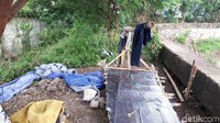 Terlihat ada semacam tempat tidur yang disusun dari bambu dan di atasnya ada tumpukan plastik.