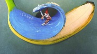 Lukisan ini dibuat Brusche dalam rangka Hari Surfing Internasional. Terlihat seorang kurcaci sedang berselancar. Terlihat seperti sedang di laut, padahal di atas pisang. Keren! Foto: Instagram @isteef