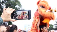 Seorang warga mengabadikan atraksi barongsai.