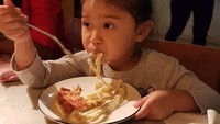 Cucu cantiknya yang bernama Ayla ini bukan hanya suka bikin pizza tapi juga suka makan. Ia asyik menyantap pasta. Sluuurrp! Foto: Instagramnya @indrowarkop_asli