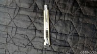 Mang Ade memotong double tape dengan cutter supaya pas dengan blangko.