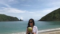 Kalo ini Gracia memasang pose naturalnya di belakang birunya hamparan laut sambil menikmati es kelapa yang segar. Foto: Instagram @graciaz14