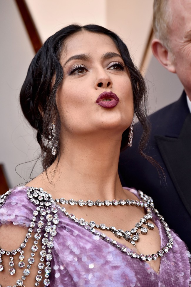 Salma menyempurnakan gayanya dengan hair do bergaya old-Hollywood glamour dan lipstik berwarna merah gelap. (Foto: Getty Images)