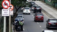 Polisi menilang pengendara yang menerobos jalur cepat.