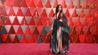 Rita Hayek tampil menawan dengan dress warna-warni yang menampilkan belahan dada serta kaki jenjangnya. Neilson Barnard/Getty Images.