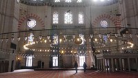 Bagian dalam masjid dibuat dengan begitu indahnya. Bagian atasnya berhias kaligrafi. Lampu-lampu menggantung dari langit-langit dan ditata melingkar (Kurnia/detikTravel)