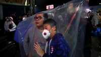 Mereka berdoa kepada dewa untuk pertolongan. Dewa Keilah Kudus Guan memberi jawaban, bahwa dia akan berkeliling ke rumah-rumah dengan tandu suci. Jadi setiap jalan yang dilewati tenda suci, penduduk harus menyalakan petasan dan mengikuti tandu suci dewa tersebut (Tyrone Siu/Reuters)