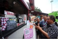Menteri Komunikasi dan Informatika Rudiantara didampingi oleh Direktur Bisnis Konsumer BNI Anggoro Eko Cahyo mencoba langsung aplikasi yap! untuk membeli makanan di Jakarta International Java Jazz Festival 2018