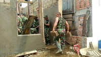 Anggota TNI melakukan bedah rumah siang malam agar Dewi segera bisa menghuni rumah itu kembali.