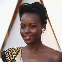 Eyeliner biru elektrik kini jadi tren. Ingin membuat eyeliner berwarna tersebut lebih kasual? Lupita Nyongo memadankannya dengan lipstik nude.  Foto: Getty Images