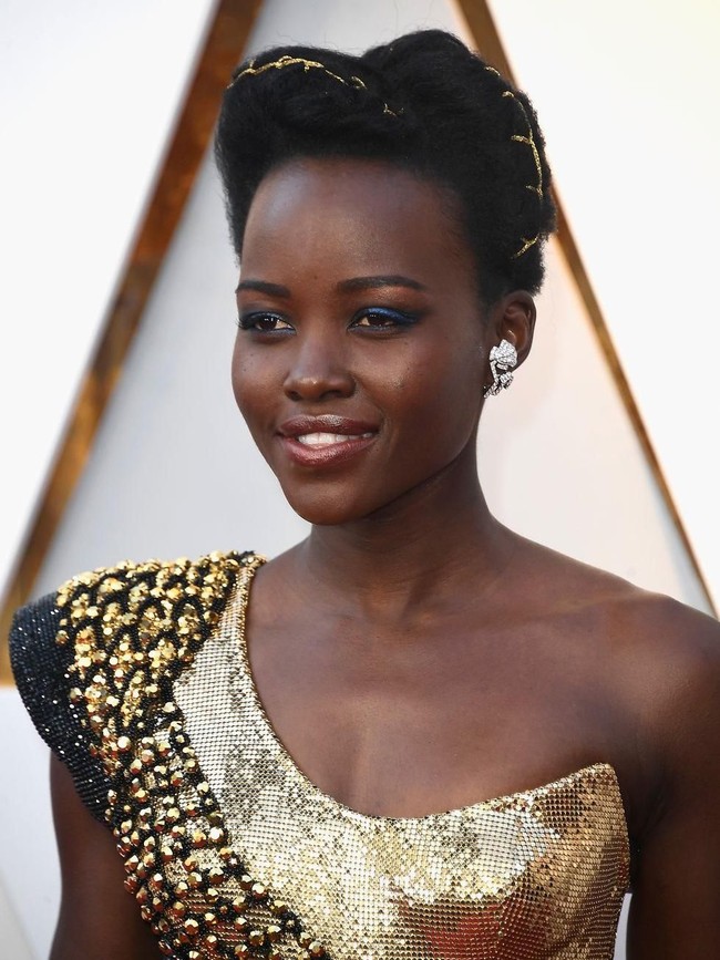 Eyeliner biru elektrik kini jadi tren. Ingin membuat eyeliner berwarna tersebut lebih kasual? Lupita Nyongo memadankannya dengan lipstik nude.  Foto: Getty Images