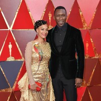 Istri Mahershala Ali, Amatus Sami-Karim memakai busana metalik dengan dua gambar burung beo di tubuhnya. Tapi jika dilihat sekilas, teksur gaunnya lebih mirip sirip ikan dibanding bulu burung beo. Foto: Getty Images