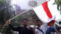Massa juga mengibarkan bendera merah putih di depan Kedubes Malaysia.