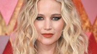 Ia tampil menawan dengan pulasan makeup dan lipstik merah. Neilson Barnard/Getty Images.
