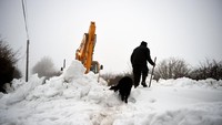Petani lokal tengan coba membersihkan salju setinggi kira-kira 6 meter di jalanan Kilteel, Irlandia (Foto: Dok. REUTERS/Clodagh Kilcoyne)
