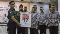 Ketua KPU Arief Budiman (tengah) menyerahkan nomor urut peserta Pemilu kepada Ketua Umum Partai Bulan Bintang (PBB) Yusril Ihza Mahendra (kiri) dan Sekretaris Jenderal PBB Afriansyah Ferry Noer (kedua kiri) disaksikan sejumlah anggota KPU di Gedung KPU, Jakarta, Selasa (6/3).