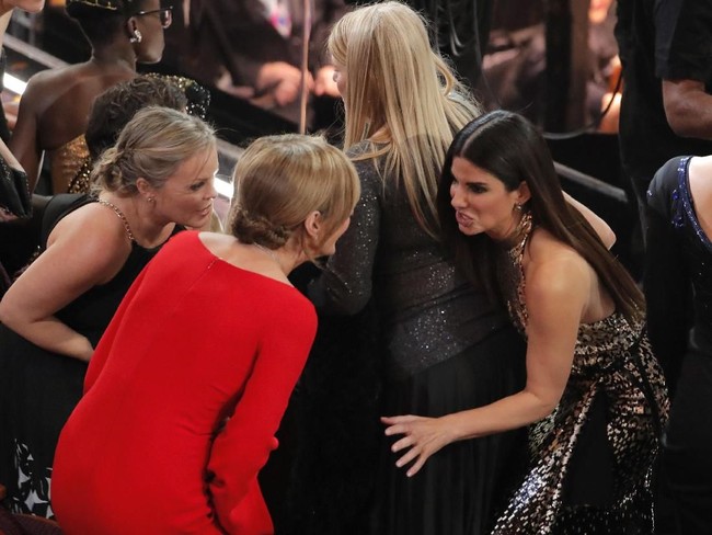 Sandra Bullock seperti sedang bergosip dengan semangat bersama wanita-wanita lainnya. Ngomongin apa, sih? Foto: Reuters