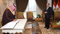 Presiden Al-Sisi menunggu MBS yang sedang memberikan tanda tangan di buku tamu saat mengunjungi Terusan Suez. Foto: The Egyptian Presidency/Handout via REUTERS